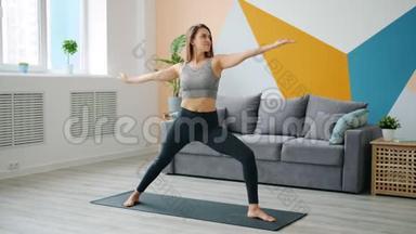 可爱的年轻女士在家里做运动，练习瑜伽垫，专注于活动